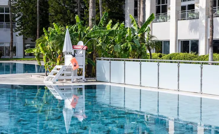Garden pool with glass safety fence and lounge area by Heavenly Outdoor in Magnolia, TX