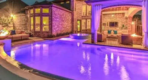 Pool lit with colored LED lighting at night