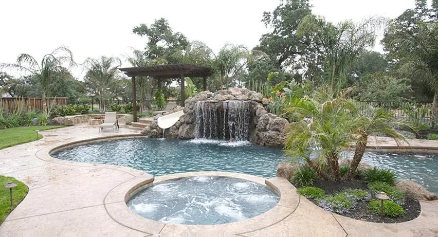 Custom slide curving into a backyard pool