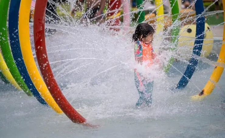 Colorful splash pad with sprayers and a dumping bucket